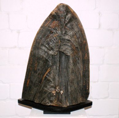 Große, künstlerisch bearbeitete Holzfigur mit einer schützenden, geschwungenen Form.