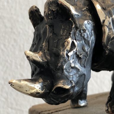 Bronzeskulptur eines Nashorns mit geschliffener Oberflächenstruktur.